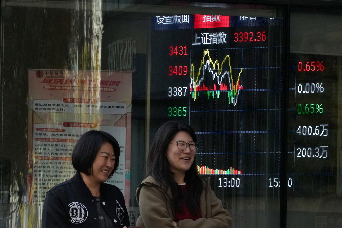 <i>Ng Han Guan/AP via CNN Newsource</i><br/>Women walk past a display showing the Shanghai stock market index outside a brokerage in Beijing on Wednesday