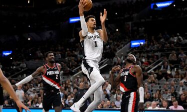 San Antonio Spurs' Victor Wembanyama goes to the basket against Portland Trail Blazers' Jerami Grant and Deandre Ayton.