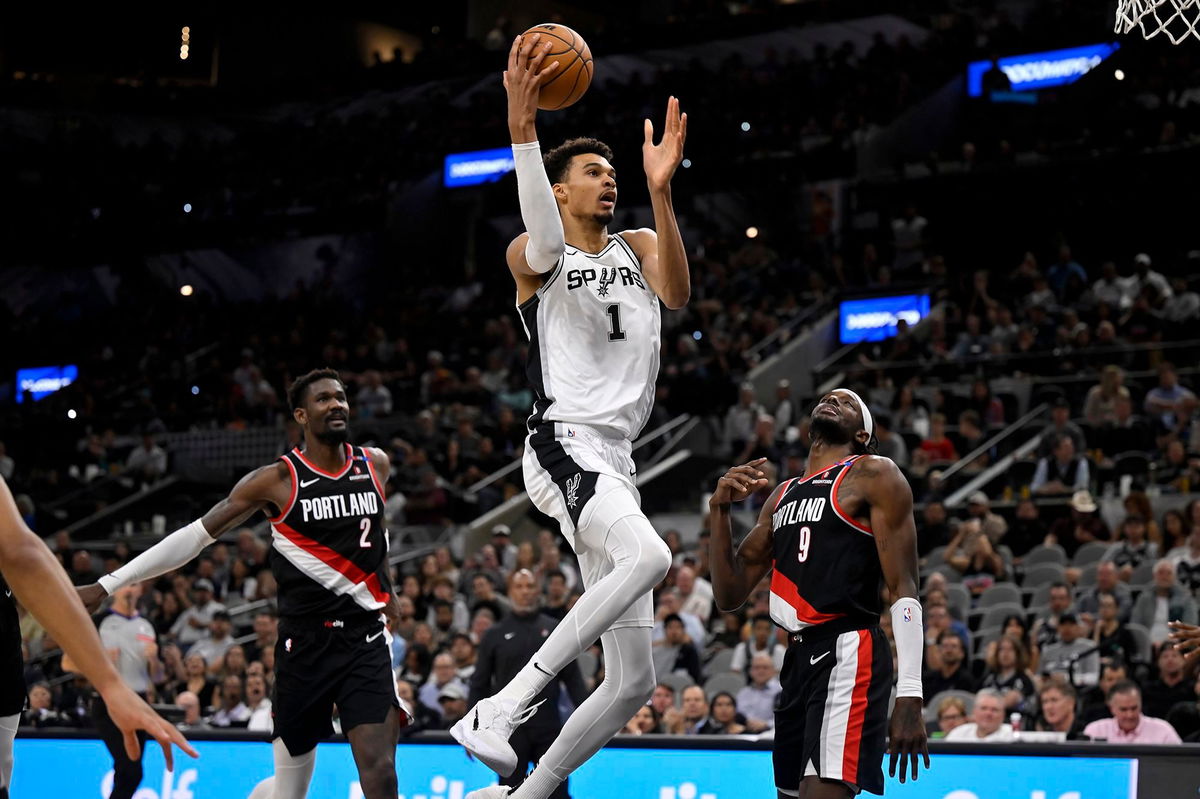 <i>Darren Abate/AP via CNN Newsource</i><br/>San Antonio Spurs' Victor Wembanyama goes to the basket against Portland Trail Blazers' Jerami Grant and Deandre Ayton.