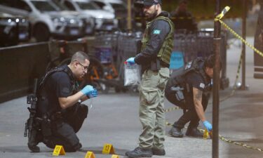 Police officers and forensic workers collect evidence at the scene of a shooting at Guarulhos international airport in Sao Paulo on November 8.