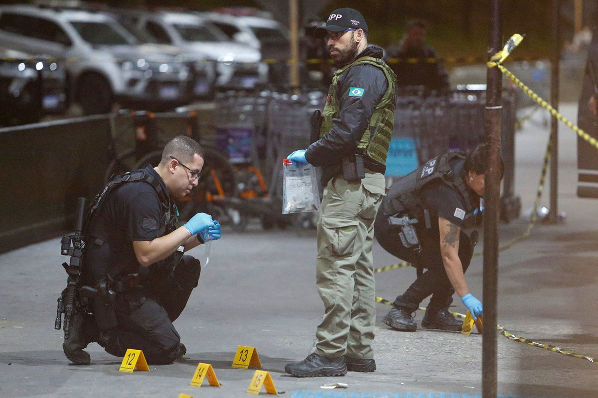 <i>Miguel Schincariol/AFP/Getty Images via CNN Newsource</i><br/>Police officers and forensic workers collect evidence at the scene of a shooting at Guarulhos international airport in Sao Paulo on November 8.