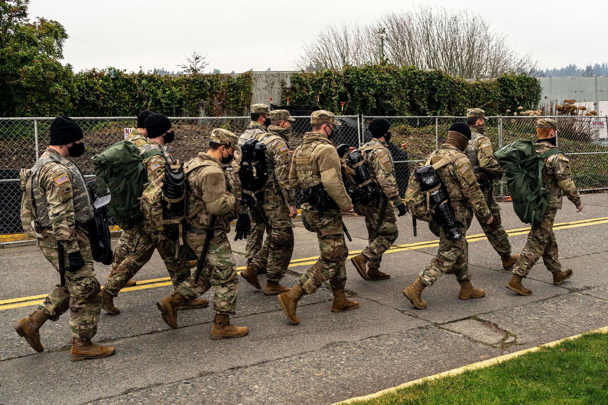 <i>David Ryder/Getty Images via CNN Newsource</i><br/>Washington National Guard personnel walk on the Washington State Capitol campus on January 20