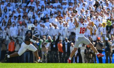 Ohio State quarterback Will Howard throws a pass while being pressured by Penn State defensive end Abdul Carter.