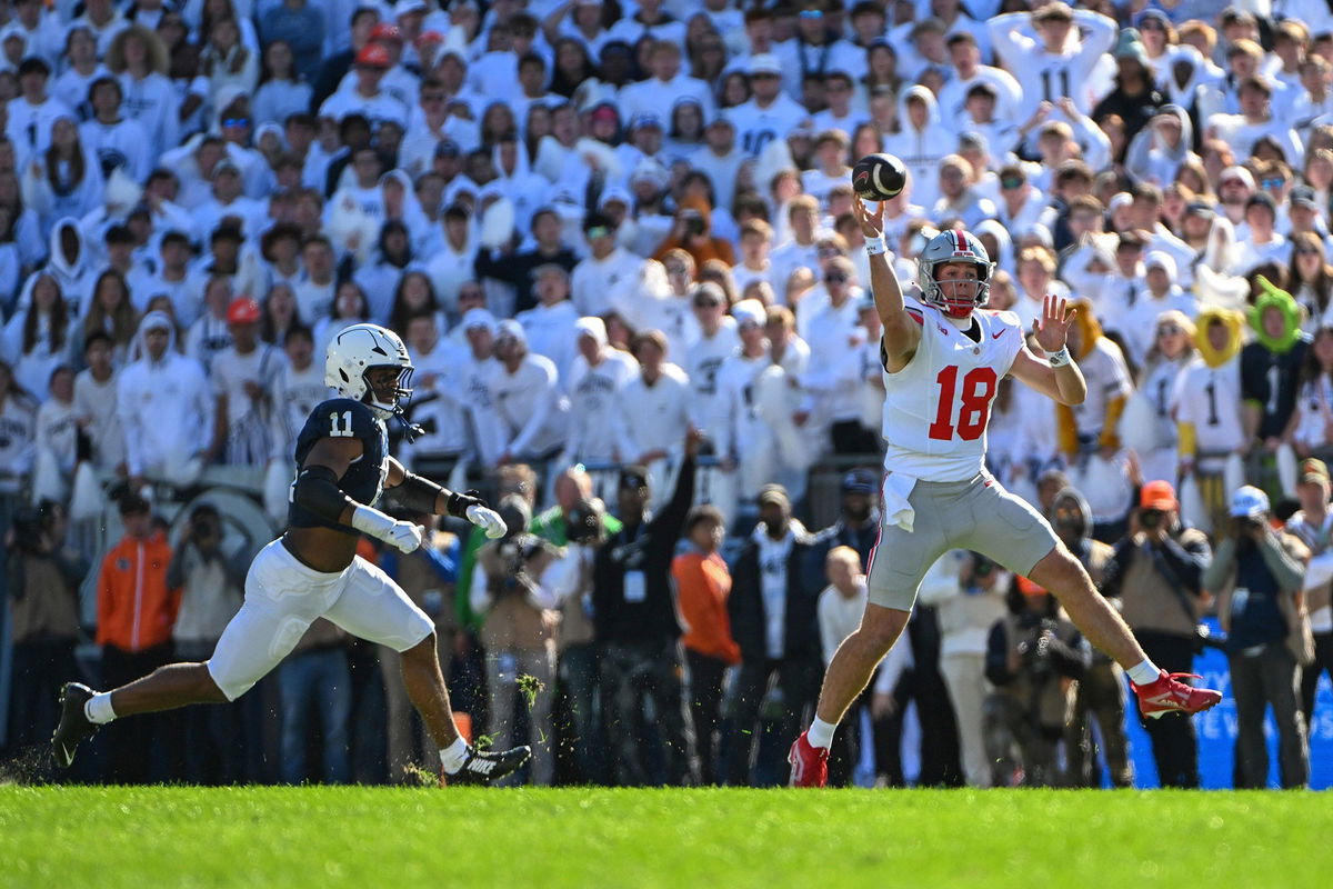 <i>Barry Reeger/AP via CNN Newsource</i><br/>Ohio State quarterback Will Howard throws a pass while being pressured by Penn State defensive end Abdul Carter.