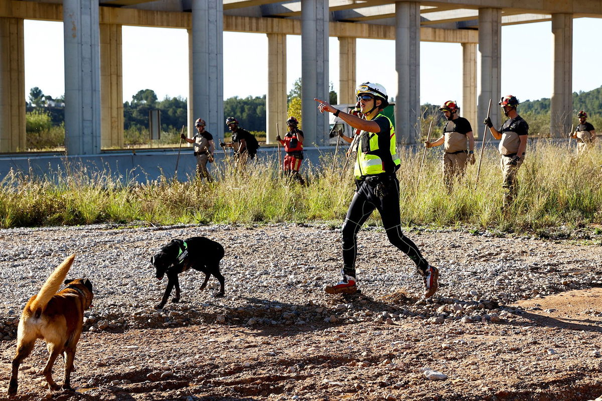 <i>Bruna Casas/Reuters via CNN Newsource</i><br/>Search and rescue team members look for bodies following flooding in Chiva