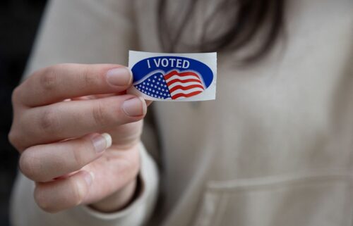 A woman shows off her "I Voted" sticker after dropping off her mail- in ballot at the Allegheny County Office Building in Pittsburgh