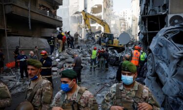 Civil defense members work as Lebanese army soldiers stand guard at the site of an Israeli strike in the Basta neighborhood of Beirut