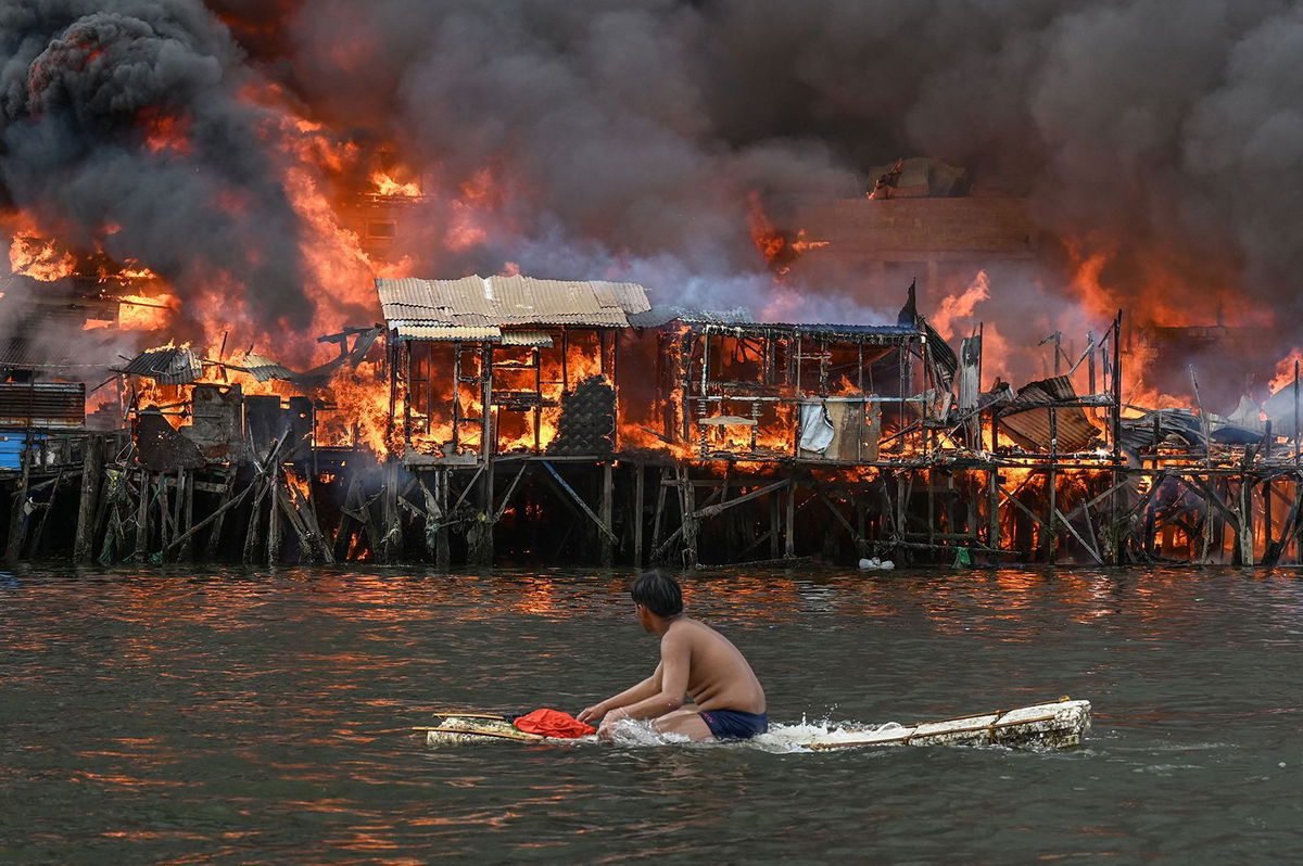 <i>Jam Sta Rosa/AFP/Getty Images via CNN Newsource</i><br/>A man watches houses on fire at Tondo in Manila on November 24