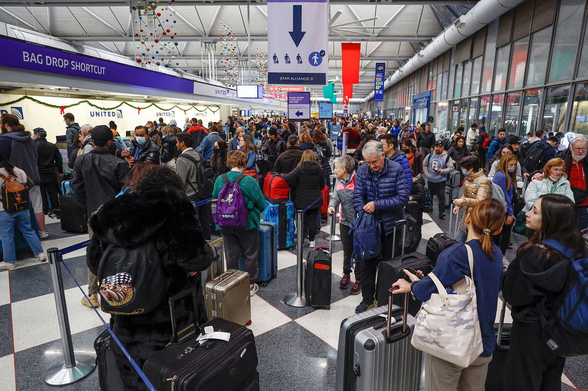 <i>Kamil Krzaczynski/AFP/Getty Images via CNN Newsource</i><br/>Travelers arrive for their flights at the United Airlines Terminal 1 ahead of the Christmas Holiday