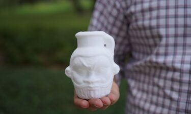 Davide Tanasi holds a 3D-generated replica of the Egyptian Bes mug.