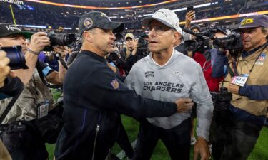 Baltimore Ravens head coach John Harbaugh (left) hugs his brother