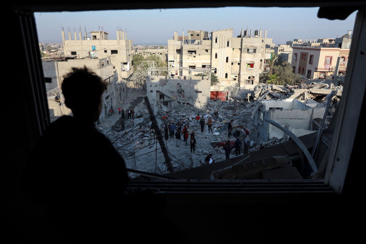 <i>Abd Elhkeem Khaled/Reuters via CNN Newsource</i><br/>A Palestinian man looks out of a damaged window as he views the site of an Israeli strike on a house