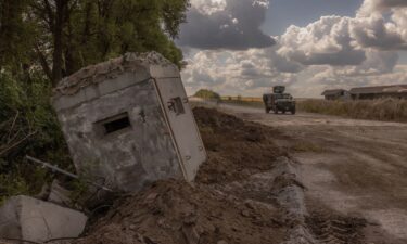 Ukrainian service members drive an armored military vehicle past a destroyed border crossing point with Russia in the Sumy region on August 14.