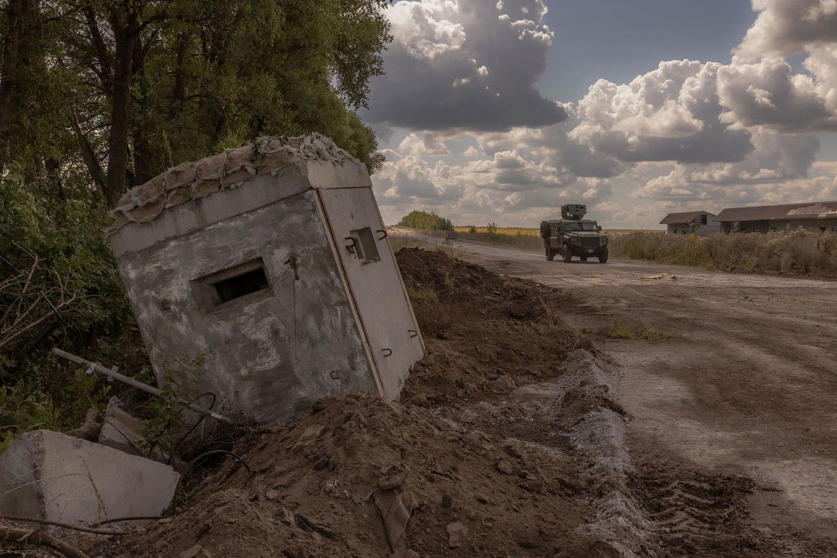 <i>Roman Pilipey/AFP/Getty Images/FILE via CNN Newsource</i><br/>Ukrainian service members drive an armored military vehicle past a destroyed border crossing point with Russia in the Sumy region on August 14.