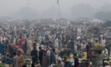 Traders and customers at a wholesale fruit market engulfed in smog in Lahore on November 8.