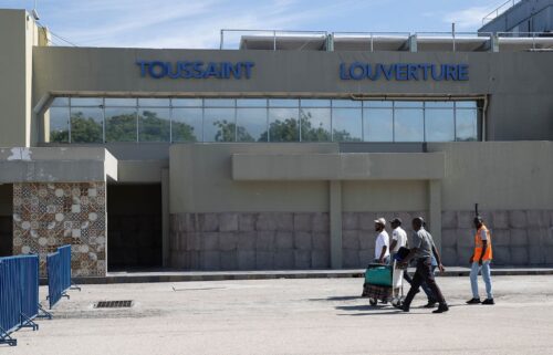 Travelers walk in front of the Toussaint Louverture International Airport in Port-au-Prince in May 2024.