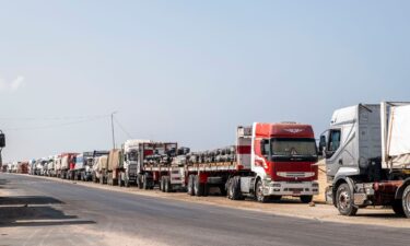 Trucks with aid destined for the Gaza Strip are parked on the side of the road in Arish