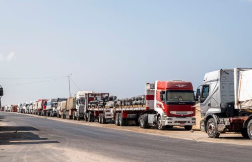 Trucks with aid destined for the Gaza Strip are parked on the side of the road in Arish