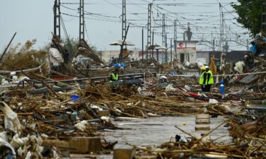 Agents stand amid debris during rain in Paiporta