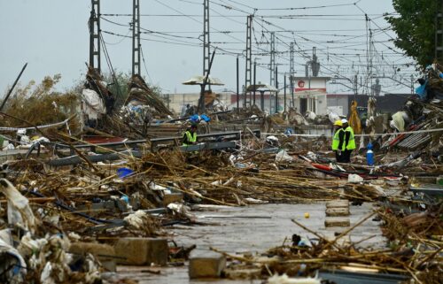 Agents stand amid debris during rain in Paiporta