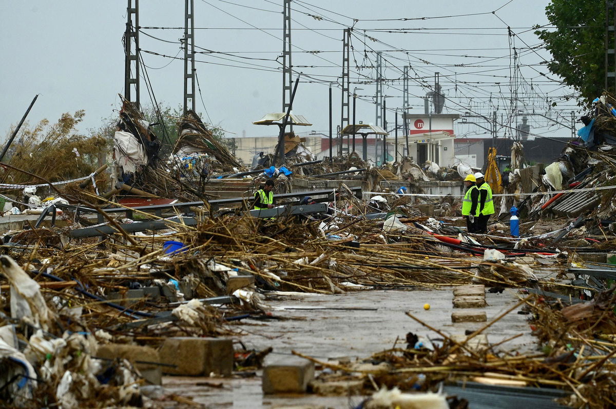 <i>Jose Jordan/AFP/Getty Images via CNN Newsource</i><br/>Agents stand amid debris during rain in Paiporta