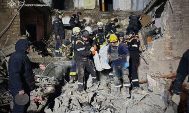 Rescuers carry Olena's body out of the rubble.