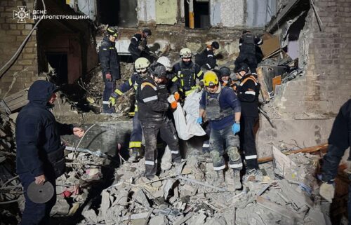 Rescuers carry Olena's body out of the rubble.