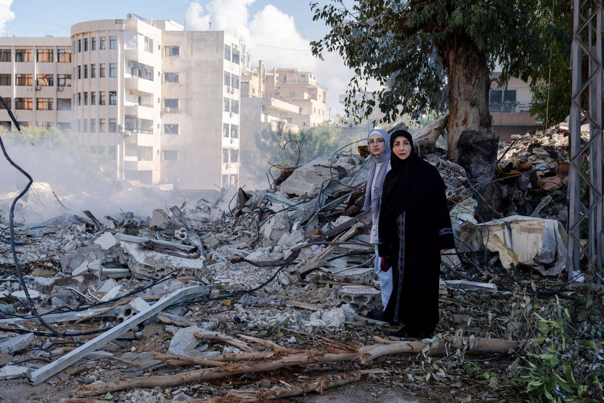 <i>Ashley Chan/SOPA Images/Sipa/AP via CNN Newsource</i><br/>Two women stand next to destruction in the city center of Tyre