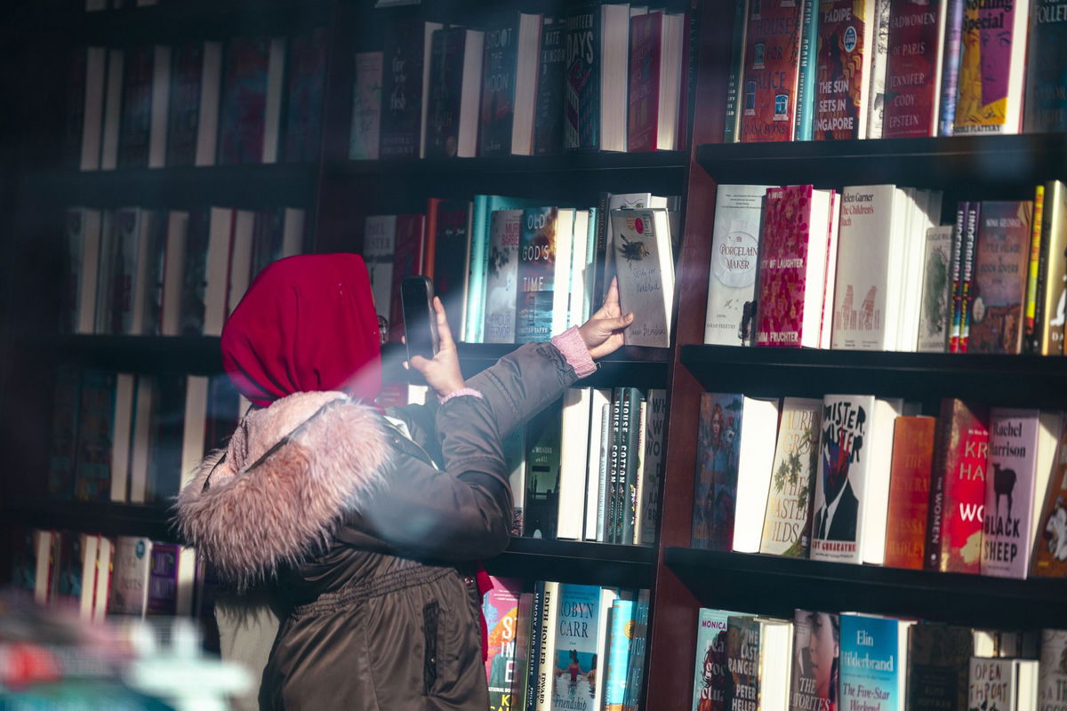 <i>Angus Mordant/Bloomberg/Getty Images via CNN Newsource</i><br/>A shopper photographs a book inside a Barnes & Noble bookstore in New York