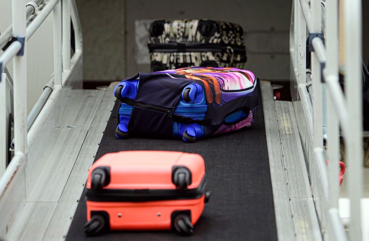 <i>Robert Michael/picture alliance/Getty Images via CNN Newsource</i><br/>Suitcases roll onto a plane at Dresden International Airport in Germany. Your bags have a better chance of arriving at your destination on time if you come to the departing airport on time.