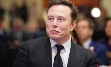 Elon Musk listens as President-elect Donald Trump addresses a House Republican Conference meeting at the Hyatt Regency on Capitol Hill on November 13