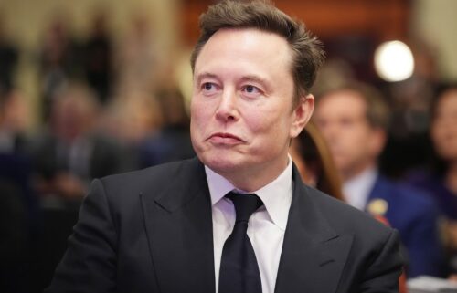 Elon Musk listens as President-elect Donald Trump addresses a House Republican Conference meeting at the Hyatt Regency on Capitol Hill on November 13