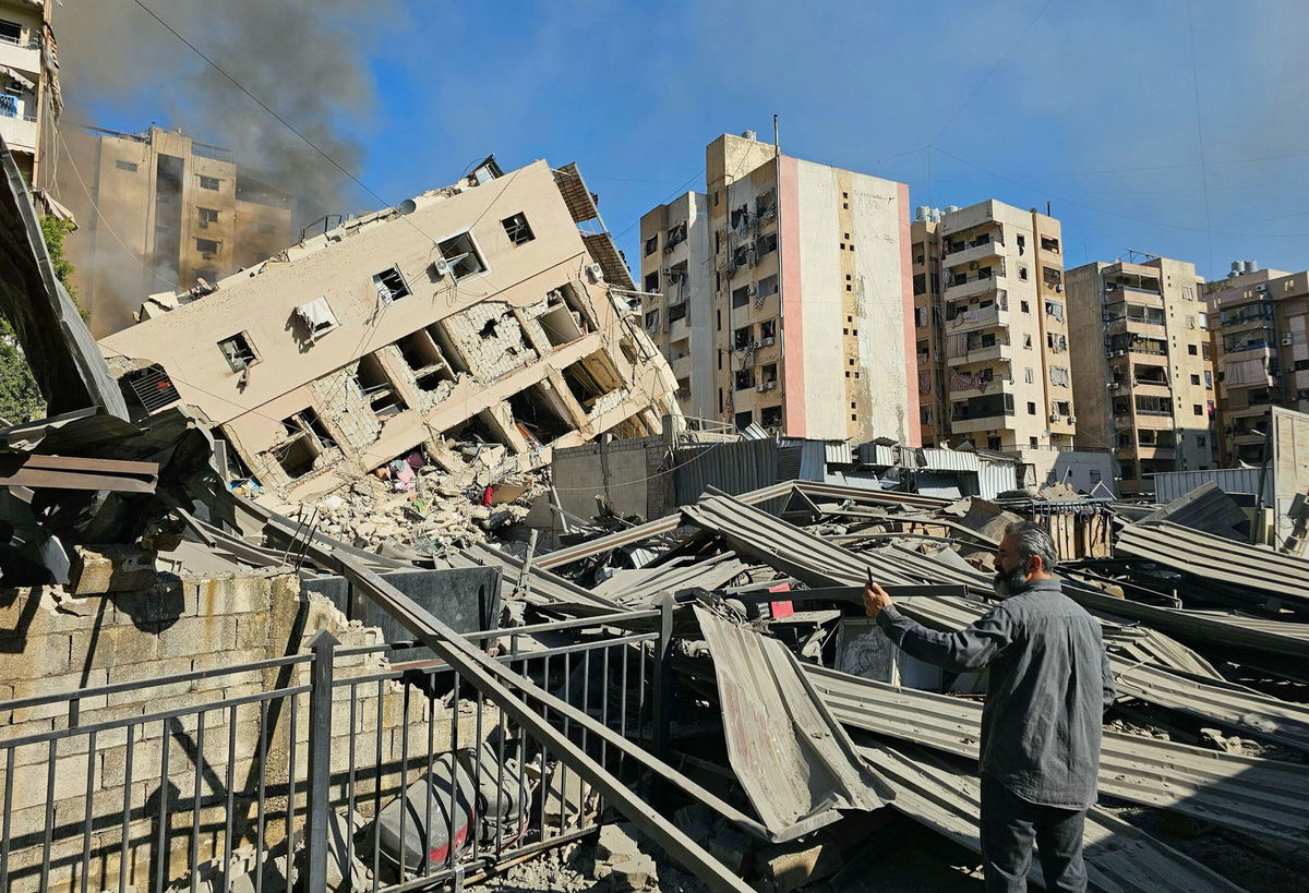 <i>AFP/Getty Images via CNN Newsource</i><br/>A man watches smoke rising behind a destroyed building following an Israeli airstrike on the district of Haret Hreik in Beirut's southern suburbs on November 16