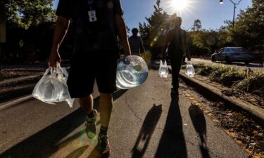 People walk with water collected from a truck in Asheville