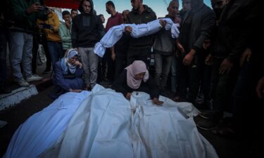 Palestinians mourn near their relatives' funerals after Israeli airstrike hit Bureij Camp in Deir al-Balah