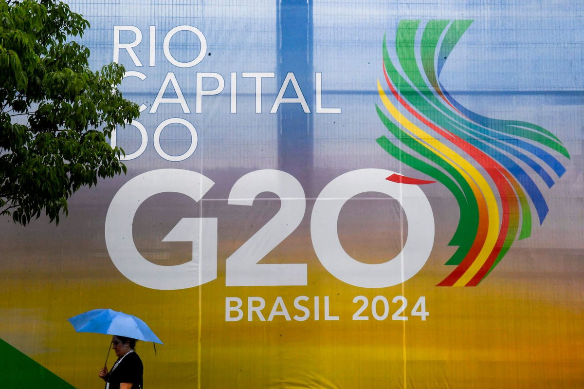 <i>Daniel Ramalho/AFP/Getty Images via CNN Newsource</i><br/>A woman walks carrying an umbrella during the G20 Social Summit in Rio de Janeiro