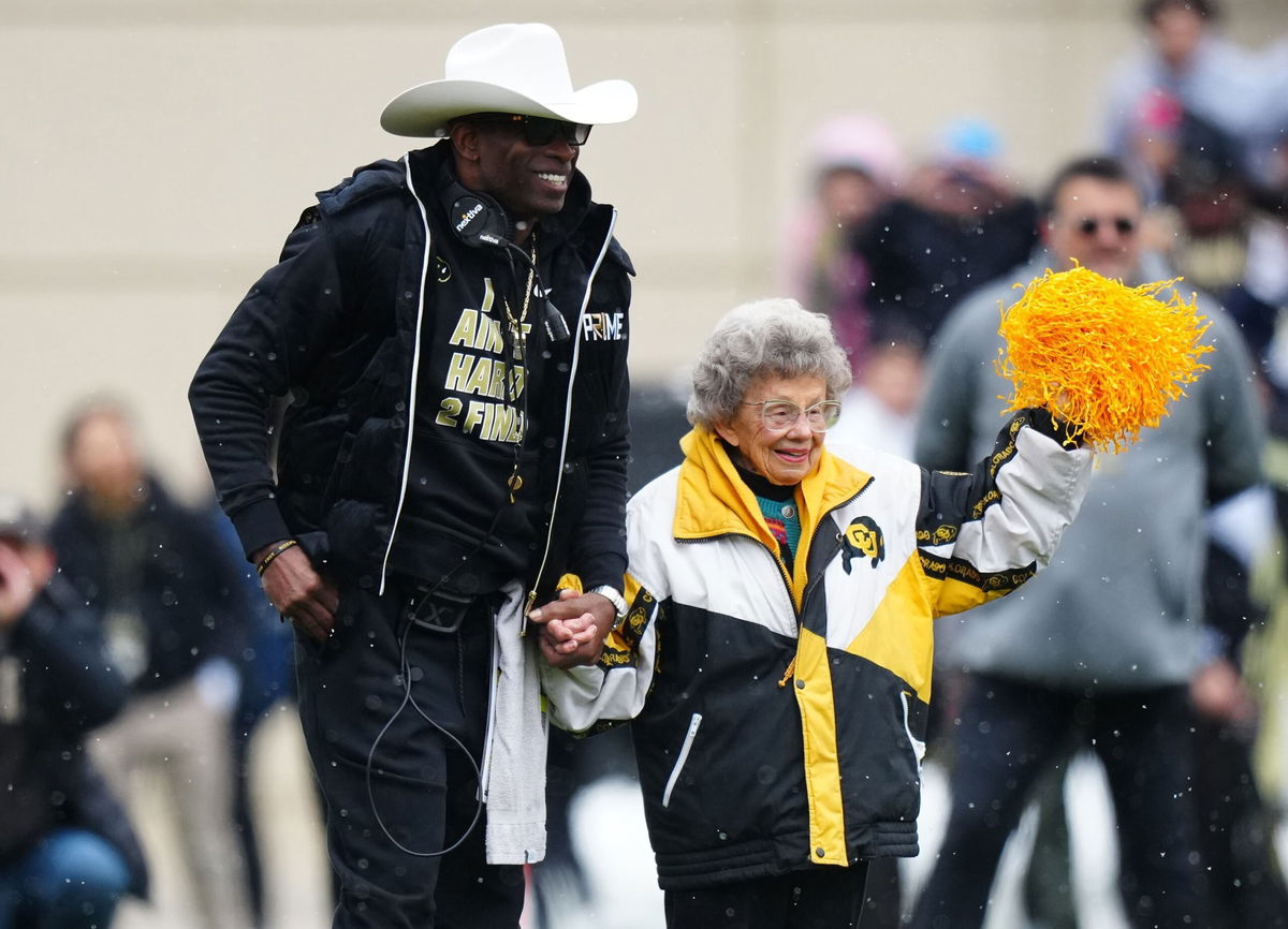 <i>Ron Chenoy/USA Today Sports/Reuters/File via CNN Newsource</i><br/>Colorado Buffaloes head coach Deion Sanders holds Peggy Coppom's hand before the Buffs' spring game at Folsom Field.