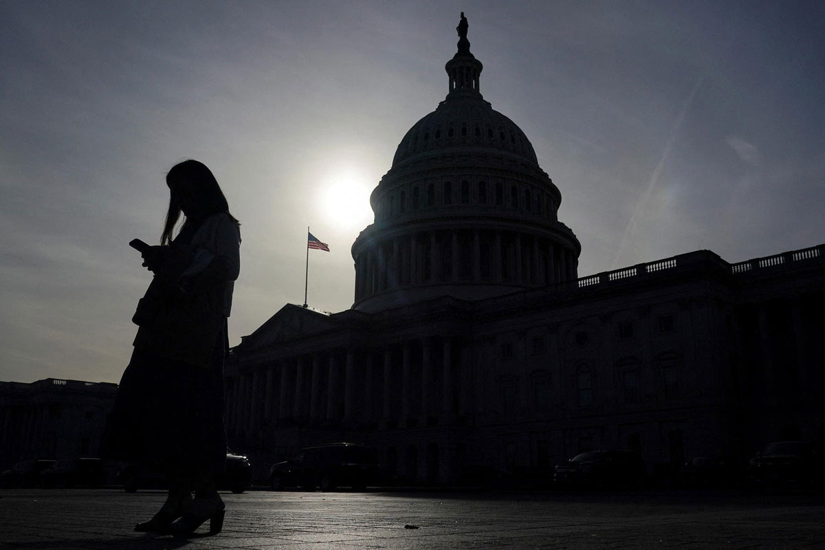 <i>Nathan Howard/Reuters/File via CNN Newsource</i><br/>A person uses a phone with the US Capitol building in the background in Washington