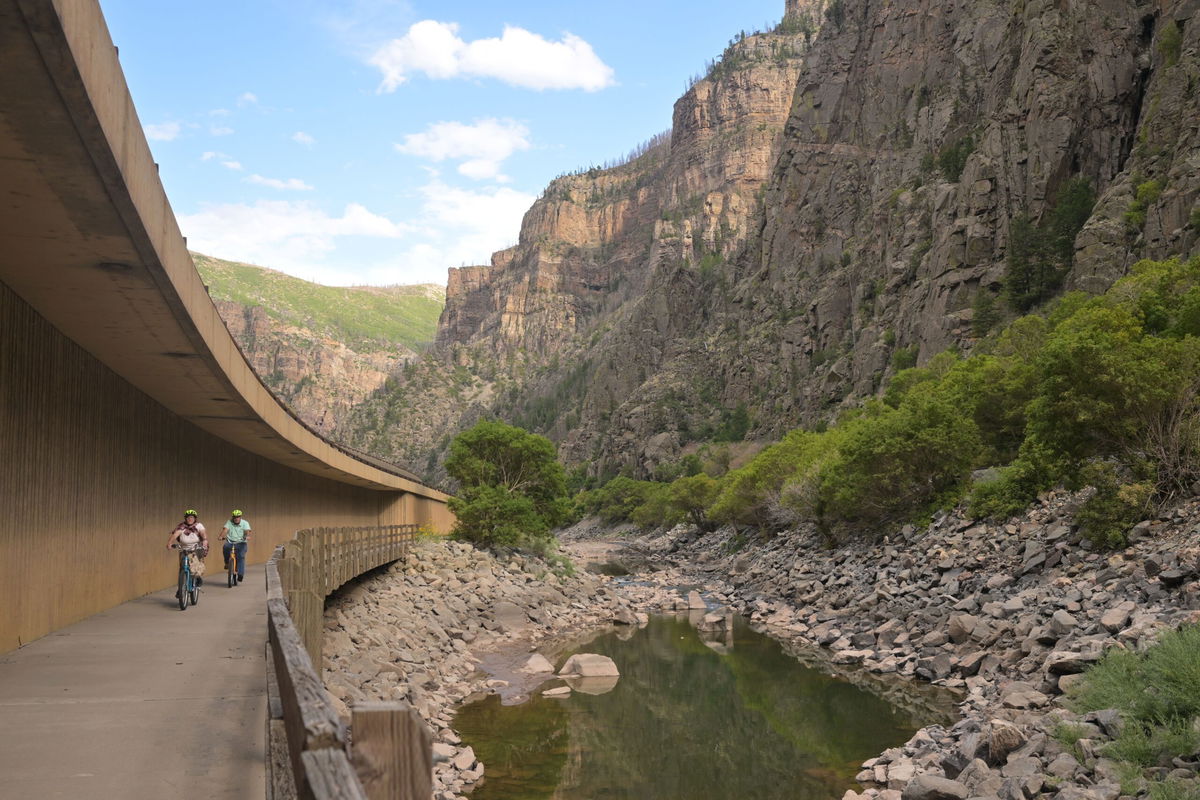 <i>J Sangosti/The Denver PostGetty Images/File via CNN Newsource</i><br/>Bike riders pedal past a section of the Colorado River east of Glenwood Springs