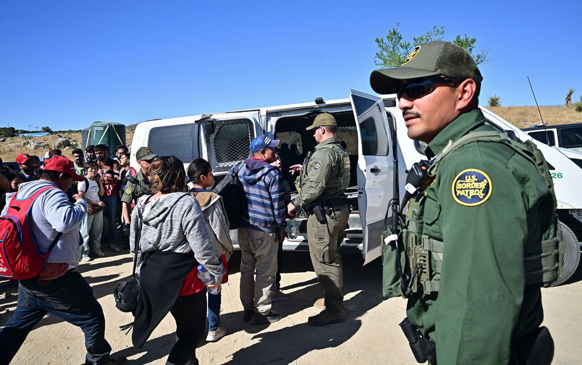 <i>Frederic J. Brown/AFP/Getty Images via CNN Newsource</i><br/>Customs and Border Patrol agents load migrants into a vehicle after groups of migrants walked into the US from Mexico at Jacumba Hot Springs