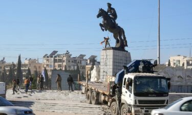 Rebel fighters prepare to topple the equestrian statue of Bassel-al-Assad