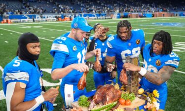 Lions players celebrate beating the Bears by eating turkey with David Montgomery (left) munching on a carrot.