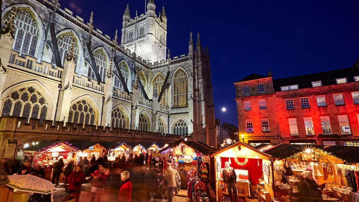 <i>Allan Baxter/Stockbyte Unreleased/Getty Images via CNN Newsource</i><br/>The Bath Christmas Market is illuminated at night behind Bath Abbey.