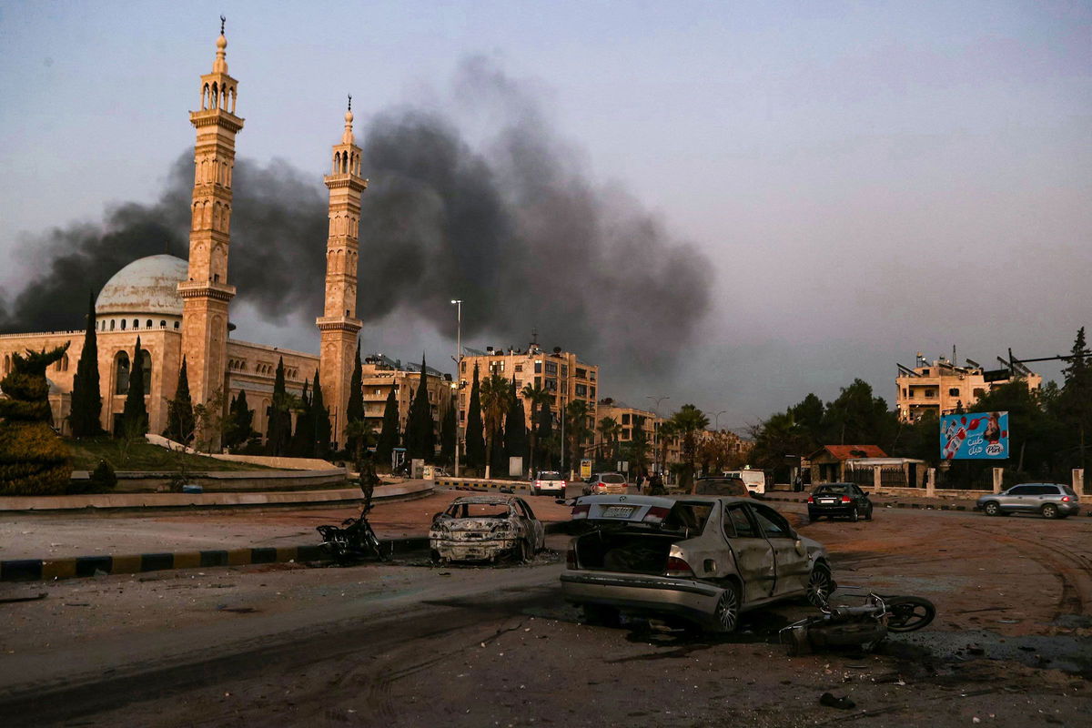 <i>Aaref Watad/AFP/Getty Images via CNN Newsource</i><br/>Smoke billows in the distance as damaged cars are seen at the site of Syrian regime airstrikes targeting opposition fighters in Aleppo