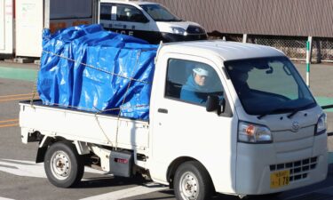 A minitruck carries a bear after it was trapped at a supermarket in Akita