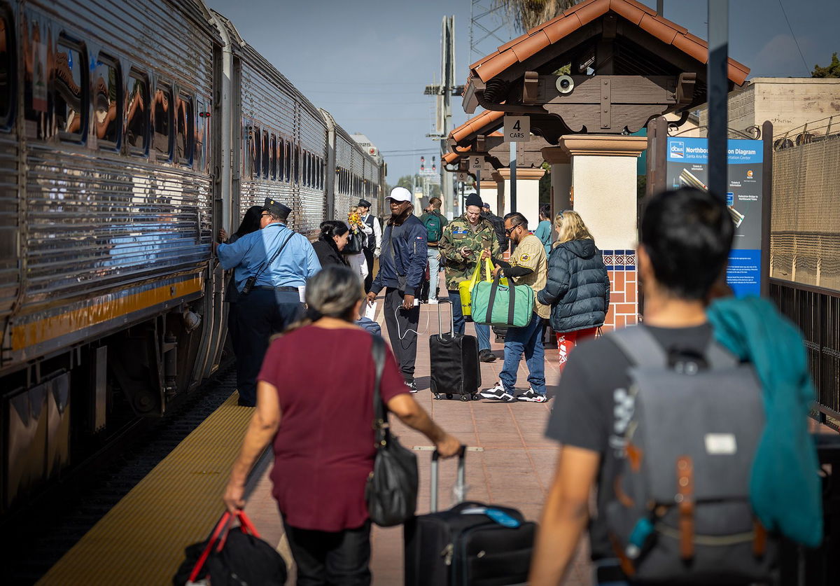 <i>Allen J. Schaben/Los Angeles Times/Getty Images via CNN Newsource</i><br/>Passengers at the Santa Ana Regional Transportation Center in California board the Amtrak Surfliner for post-Thanksgiving travel.