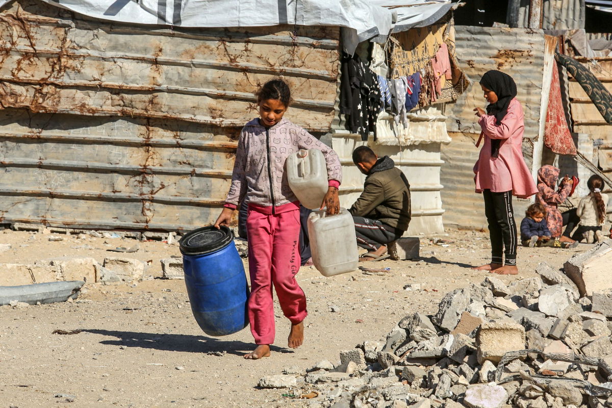 <i>Abed Rahim Khatib/Anadolu/Getty Images via CNN Newsource</i><br/>A young girl carries jerry cans in Khan Yunis on December 4.