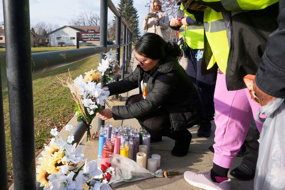 <i>Morry Gash/AP via CNN Newsource</i><br/>A resident places some flowers outside the Abundant Life Christian School on Tuesday