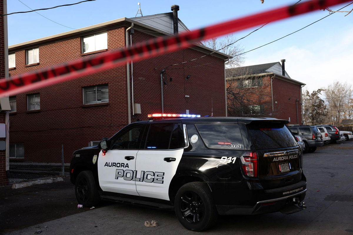 <i>Kevin Mohatt/Reuters via CNN Newsource</i><br/>An Aurora Police vehicle blocks an alleyway after law enforcement responded to an armed home invasion at The Edge at Lowry apartments in Aurora