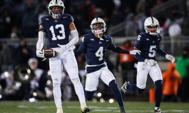 Tony Rojas of the Penn State Nittany Lions celebrates with AJ Harris and Cam Miller after intercepting a pass against Maryland during the first half at Beaver Stadium on November 30 in Happy Valley.